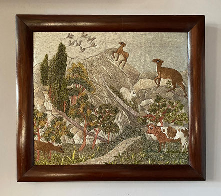 A large early 19th century naive silkwork of animals in a mountainous landscape