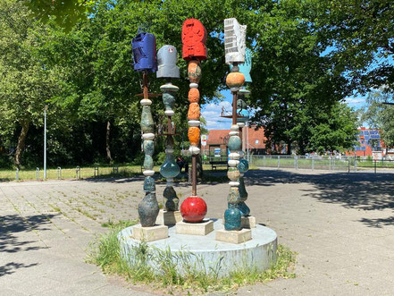 Fünf in den Himmel ragende Einzelsäulen auf einem runden Betonfuß - "Vom Gehen + Kommen" ist ein Kunstprojekt im öffentlichen Raum in Bremen-Kattenturm, Bremen Obervieland (Foto: 05-2020, Jens Schmidt)