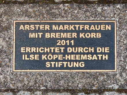 Inschrift der Bronzeplastik "Arster Marktfrauen mit Bremer Korb 2011, erreichtet durch die Ilse Köpe-Heemsatz Stiftung" (Foto: 05-2020, Jens Schmidt)