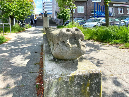 Im Hintergrund der Krokodil-Statue in Bremen-Kattenturm sind weitere Skulpturen angeordnet, nach dem Treppenaufgang sieht man den Eingangsbereich der Passage Kattenturm (Foto: 05-2020, Jens Schmidt)