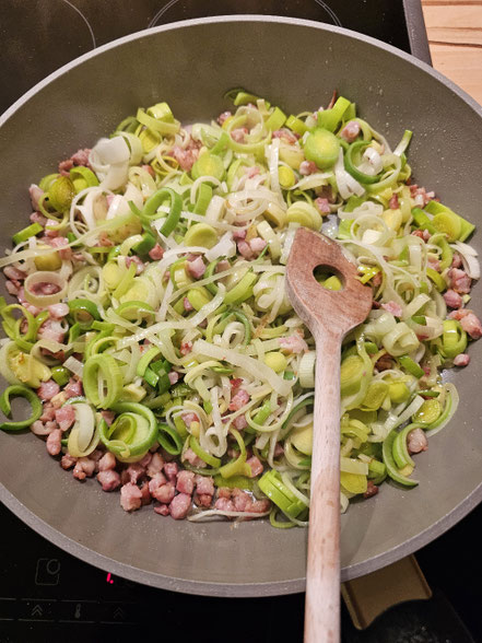 Speck und Lauch in der Pfanne anbraten für eine klassische Quiche Lorraine