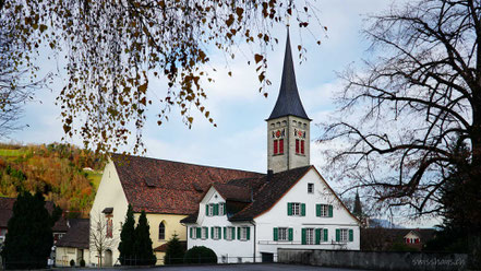 Kirche mit Kirchturm mit herbstlichen Ästen umrahmt