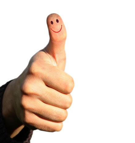Hand mit erhobenem Daumen und aufgemaltem Smiley – Symbol für Zufriedenheit und positives Feedback