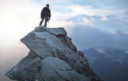 Bergsteiger steht auf dem Gipfel