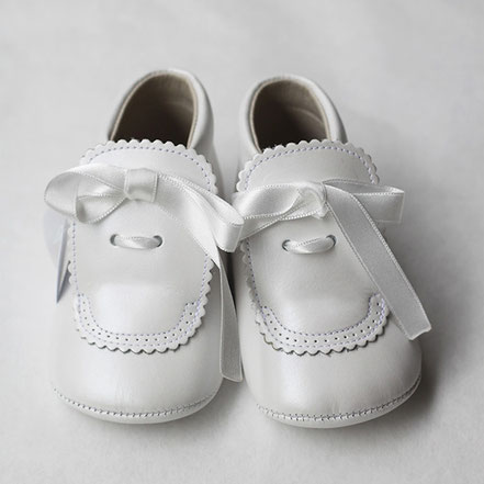 Chaussons bapteme bébé montant en cuir souple blanc cassé avec noeud en satin. Chaussons cérémonie bébé Fil de Légende. Magasin vêtements baptême cérémonie bébé Paris, Neuilly-sur-Seine.
