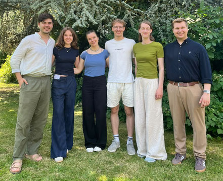 Gruppenbild des Stipendiatenbeirats. Alle sechs Mitglieder auf einer Wiese mit Hund Paul.