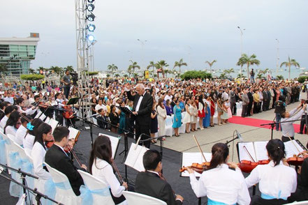 La orquesta infantojuvenil municipal entona el Himno Nacional que el público corea con civismo en la sesión solemne por el aniversario 92 del cantón. Manta, Ecuador.