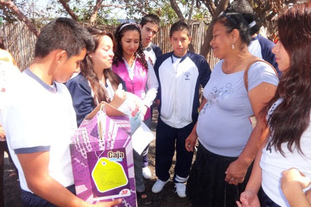 Estudiantes del primer año de bachillerato en la UE San José entregan ayuda a madre de familia damnificada de incendio. Manta, Ecuador.