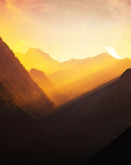Sonnenuntergang über einem tiefen Tal in einer Berglandschaft