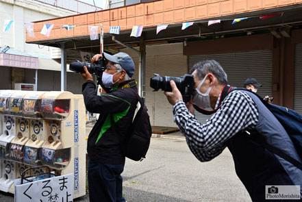 「桐ヶ丘中央商店街」で撮影に熱中する参加者たち。　　　　　