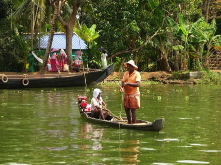 Fischer in den Backwaters während die Dorffrauen von den Reisfeldern heimkommen