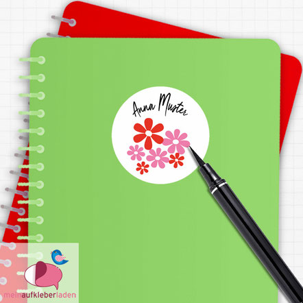 Runder Namensaufkleber weiß mit Blumen in rot und rosa zum selber beschriften auf Schulheft. 