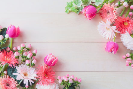 パソコンのキーボードの前に置かれたespecially for youの文字が入った桜の花びらをかたどった付箋。ピンク色のノートとボールペン。眼鏡。コーヒーの入ったピンクのマグカップ