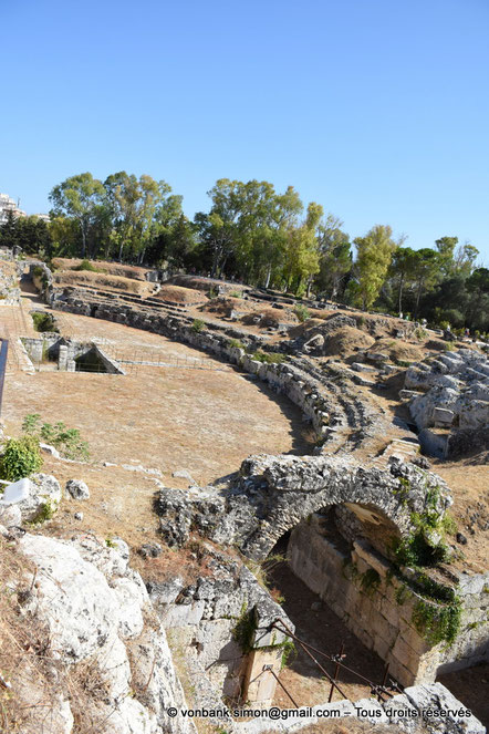 Syracuse - Amphithéâtre : Entrée Nord - au centre, l'arène et sa chambre souterraine - en arrière-plan, l'entrée Sud - sur la droite, les gradins de la partie occidentale