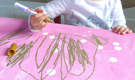 Kind malt auf Leinwand mit goldenem Stift von Edding