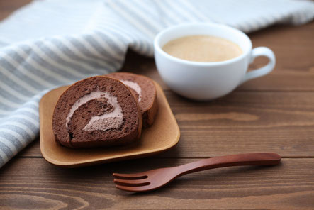 チョコレートのロールケーキが盛り付けられたお皿とコーヒーの入ったマグカップ。