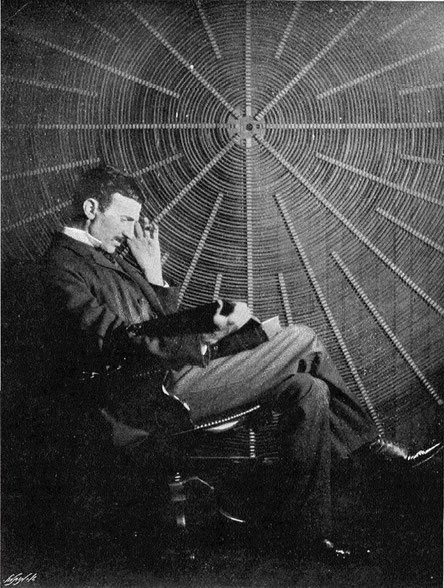 Nikola Tesla reading Maxwell's volume "scientific papers", in front of the spiral coil of his high-frequency transformer at East Houston St. 46, New York.