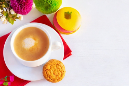 コーヒーの入ったカップ＆ソーサと焼き菓子。朱赤のナプキン。