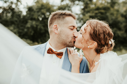 Ein glückliches Hochzeitspärchen gibt sich einen Kuss und feiert das Fest der Liebe