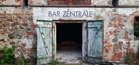 Ein alter Stall mit der Aufschrift "Bar Zentrale"