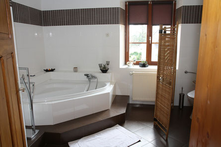 salle de bain  avec w c baignoire d'angle douche lavabo et table à langer