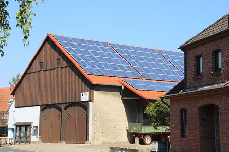 Solarpanele auf einem großen alten Haus in einem Dorf.