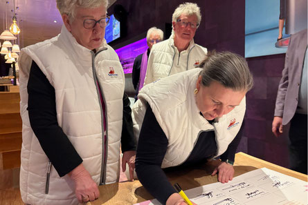 Ester Leibbrand tekent het Regenboog Stembusakkoord namens Senioren Dijk en Waard, daarna volgen Joke Appelman en Richard den Bak haar.