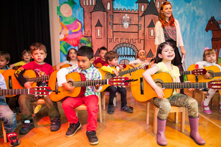 Kinder (hier bei einem Musikprojekt mehrerer Kitas in Düsseldorf) musizieren ab 4 Jahren auf der C-Gitarre