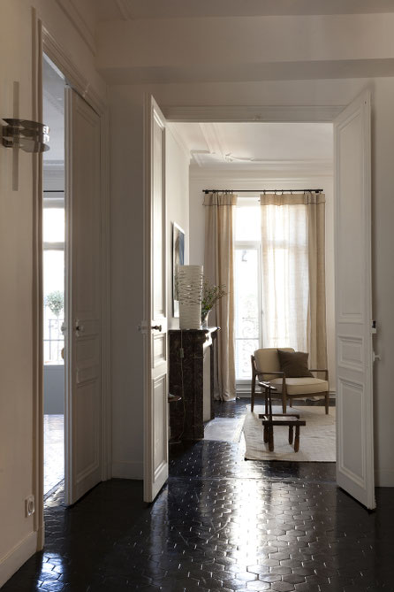 Entrée d'un appartement parisien. Tomettes teintées en noir.