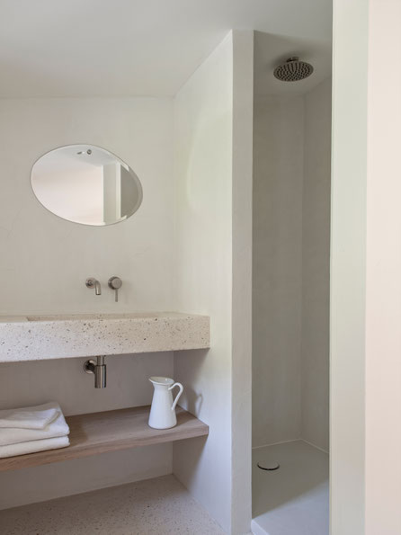 Rénovation et construction d'une annexe. Salle de bain composé d'un plan vasque en béton coulé, les murs en béton ciré, un miroir MNuance