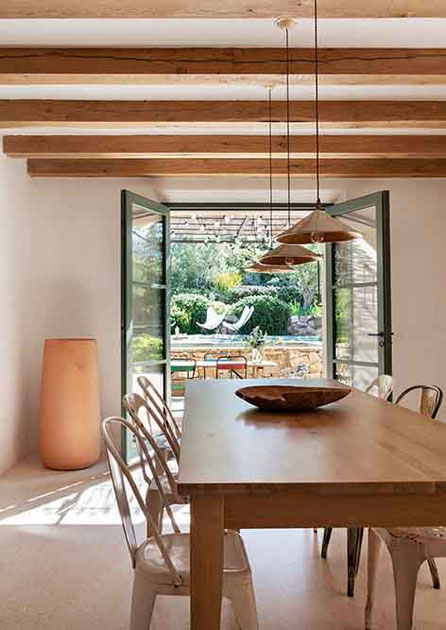 Salle à manger avec une table en bois et des chaises tolix chinées