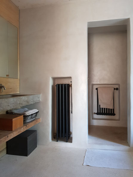 Rénovation, extension et surélévation d'une maison à Aix-en-Provence. Salle de bain master, plan vasque en pierre naturelle, murs en béton ciré