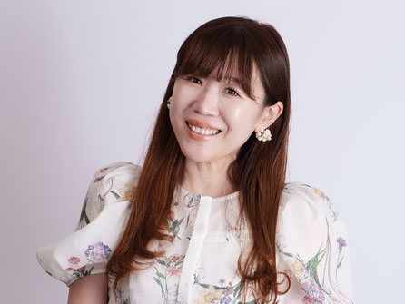 白地に花柄ワンピース姿のきょんちゃん。視線を外しながらやさしくほほえむ自然な表情の一枚。