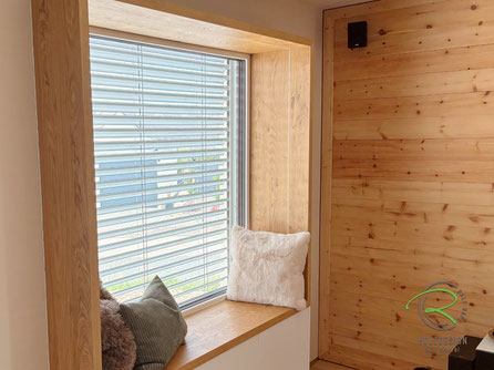 Fenstersitz mit 45 mm starkem Eichenrahmen auf Gehrung gefertigt und weißen Unterschränken, individuell gefertigt von der Schreinerei Holzdesign Ralf Rapp in der Bodenseeregion. Ideal als Leseecke oder Stauraumlösung in Radolfzeller Wohnhäusern.