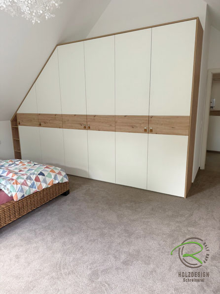 Maßgefertigter Schlafzimmerkleiderschrank von Schreinerei Holzdesign Ralf Rapp in Geisingen, Einbauschrank mit Schräge links und Eiche Dekorstreifen mit Ledergriffen und umlaufendem Eichen Rahmen, Schrank angepasst an die Dachschräge