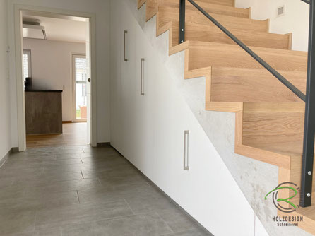 Treppenschrank mit Abstellkammer und Ausziehschränken von Schreinerei Holzdesign Ralf Rapp in Geisingen in weiß unter Faltwerktreppe in Beton & Eiche