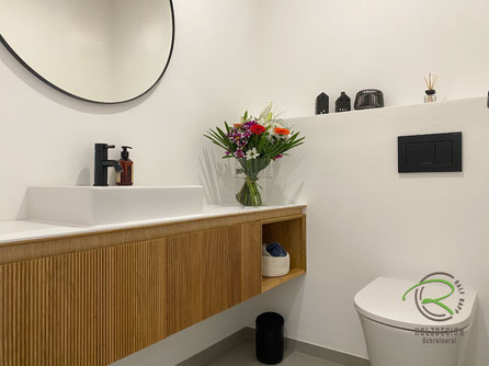 Griffloser WC-Unterschrank in Villingen im Schwarzwald für Tages-WC in Eiche mit Rillenoptik, weiß durchgefärbte Melaminharz Aufsatzplatte und auf Gehrung gefertigtem offenem Handtuchfach