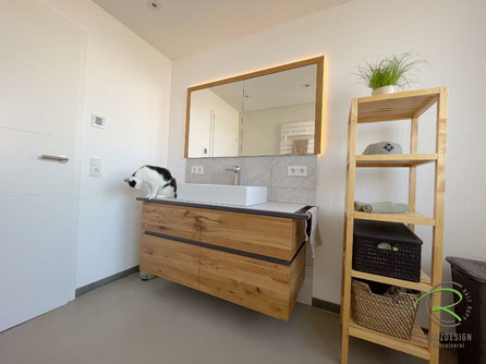 Maßgefertigter Waschtisch und Spiegelschrank in Eiche mit anthraziter, umlaufender Griffmulde, wasserfester Aufsatzplatte in hellgrau und wandeingelassener Spiegelschrank mit Eichenrahmen