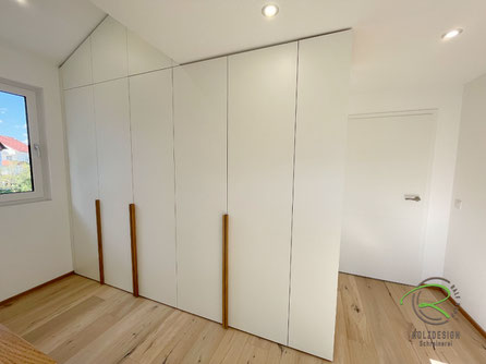 Raumhoher Kleiderschrank mit Schräge links in weiß und Eichengriffleisten maßgefertigt von Schreinerei Holzdesign Ralf Rapp in Geisingen