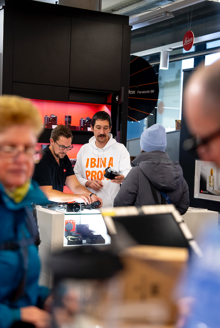 Zwei Mitarbeiter beraten eine Kundin an der Kameraauslage in der Salzburger Filiale der Kücher Digitalen Welt.