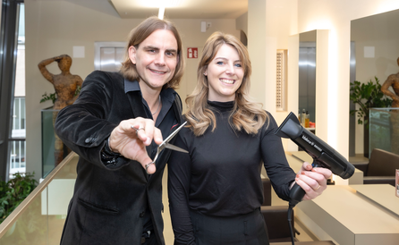 Zwei Personen im Friseursalon mit Schere und Föhn beim Sturmayr POP Up Store in Salzburg.