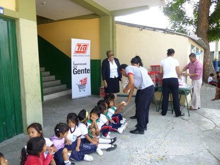 Niñitas y niñitos que se educan en la Escuela 10 de Agosto de Manta (Ecuador) reciben una ración alimenticia ofrecida por almacenes TIA con motivo de Navidad.