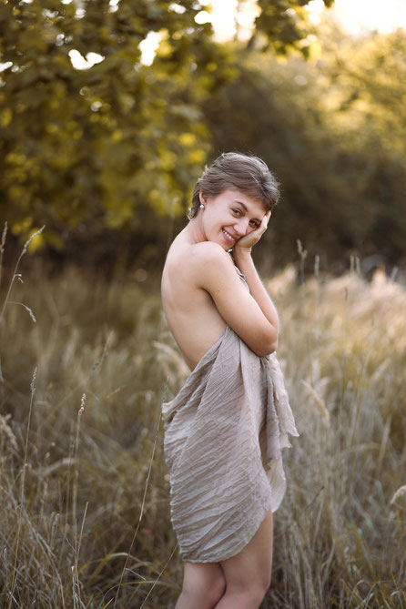 Warmes, sinnliches Portait einer jungen lachenden Frau in der Natur - aufgenommen von Portraitfotografin Malina Bura in Berlin