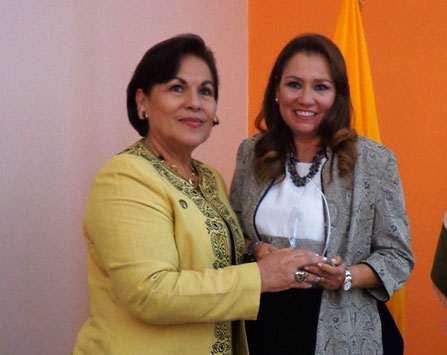 Grace Moreira de Coello entrega presea a Sandra González de Velásquez, representante del Patronato Municipal de Bolívar, Ecuador.