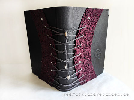 Foto-Gästebuch Hochzeit Corsage, Hardcover-Bucheinband Stoff schwarz, Corsage bordeauxfarben, Flachrelief 2 Ringe, Buchblock Büttenpapier off-white, 40 Blatt, 23cm x 29cm Hochformat