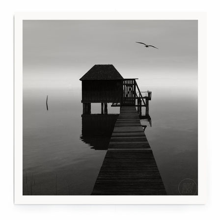 "Solitude" - Stimmungsvolle Landschaft mit Seehaus im Wasser und Holzsteg.