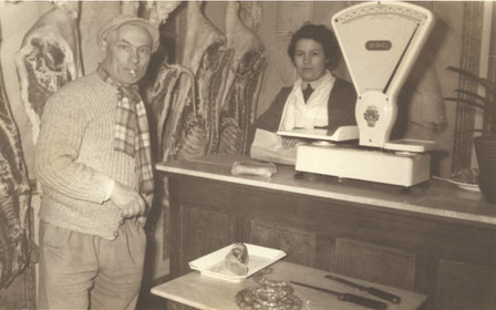 Lucienne Blanc trônant derrière son comptoir avec un fidèle client.