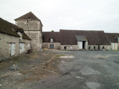 La grange à poteaux à droite, le pigeonnier et un bâtiment d'exploitation à gauche.