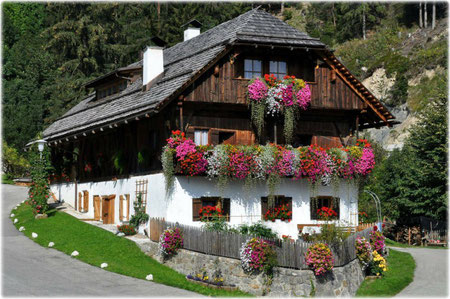 Ein gepflegter Bauernhof im Pustertal, beschmückt mit fiel Blumen