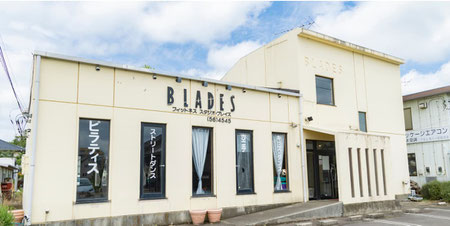 クリーム色の外壁に「blades」のロゴが入ったスタジオ外観。スロープが入り口へと続きます。